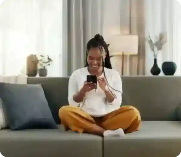 Person on couch looking at phone at tax form 1099 INT